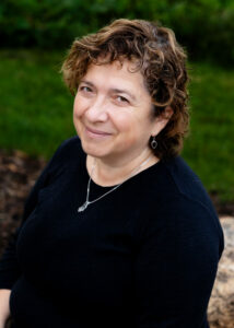 Marina Bluvshtein sits in front of a neutral background