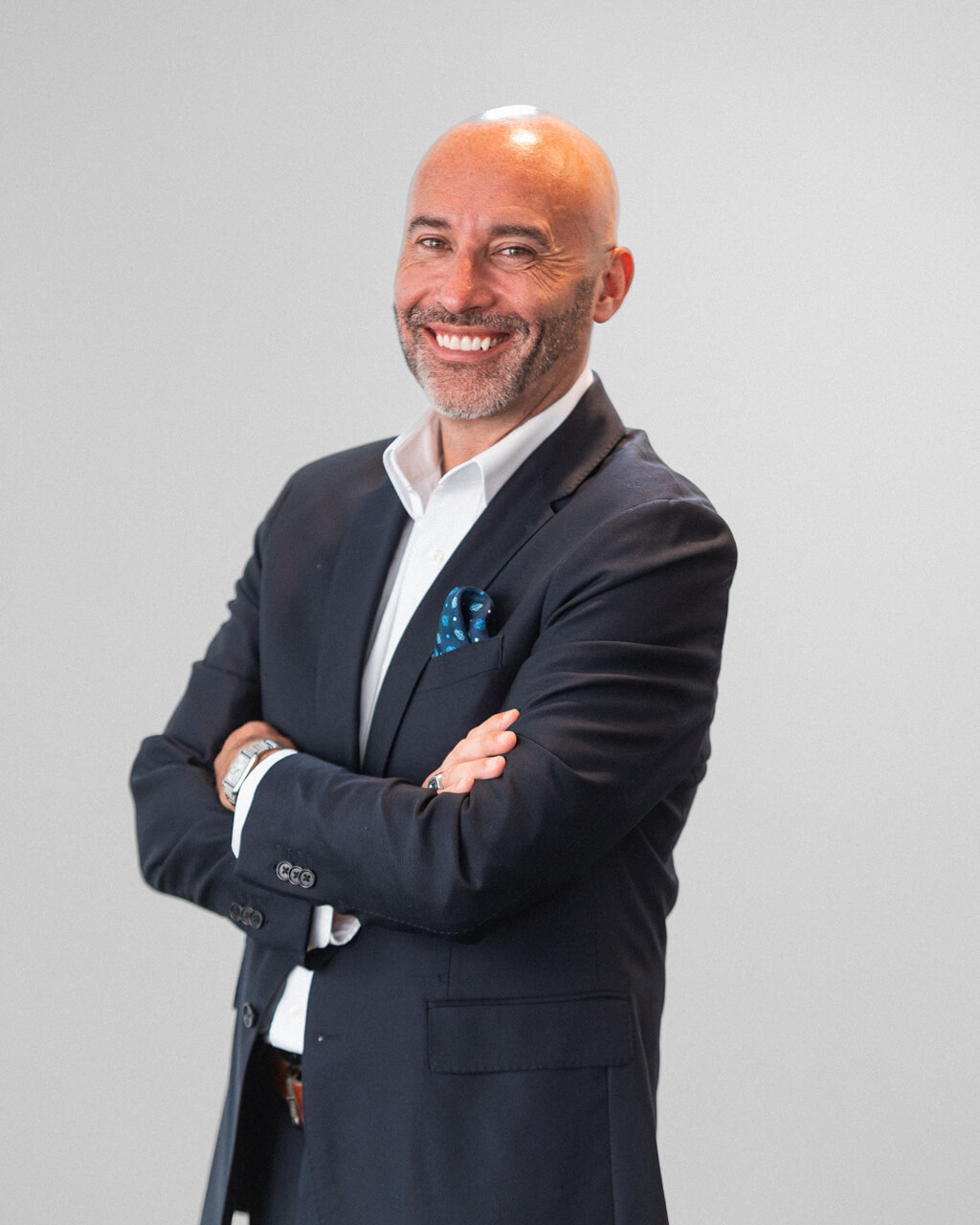 Dr. Jason Walker, Ph.D., a bald man with a beard, wears a dark suit and white shirt, standing with arms crossed and smiling against a plain light background.