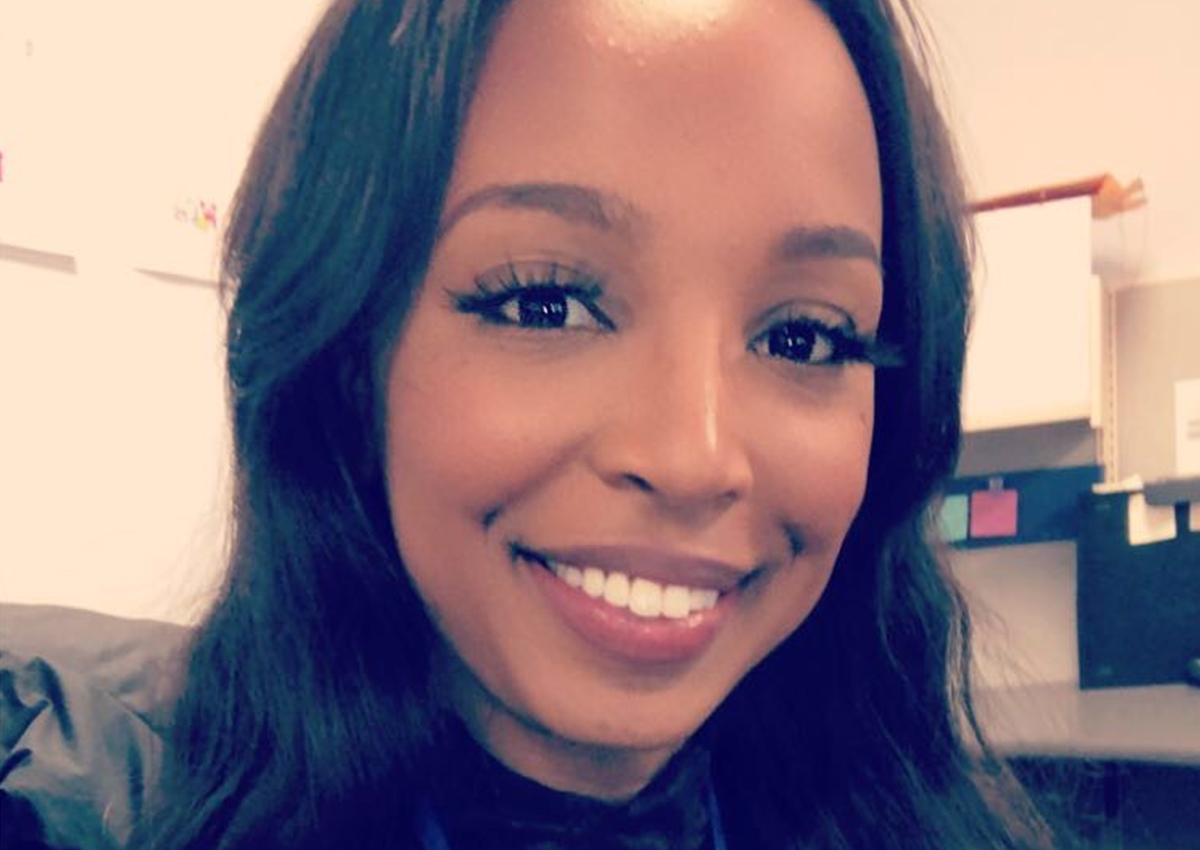 A woman with long dark hair smiles at the camera in an indoor office setting, highlighting the power of virtual connections in today’s workplace.