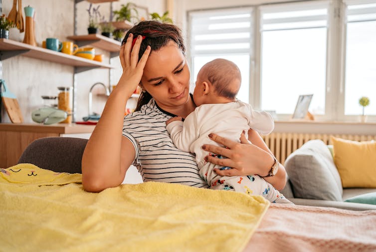 Woman sitting at table holding a baby