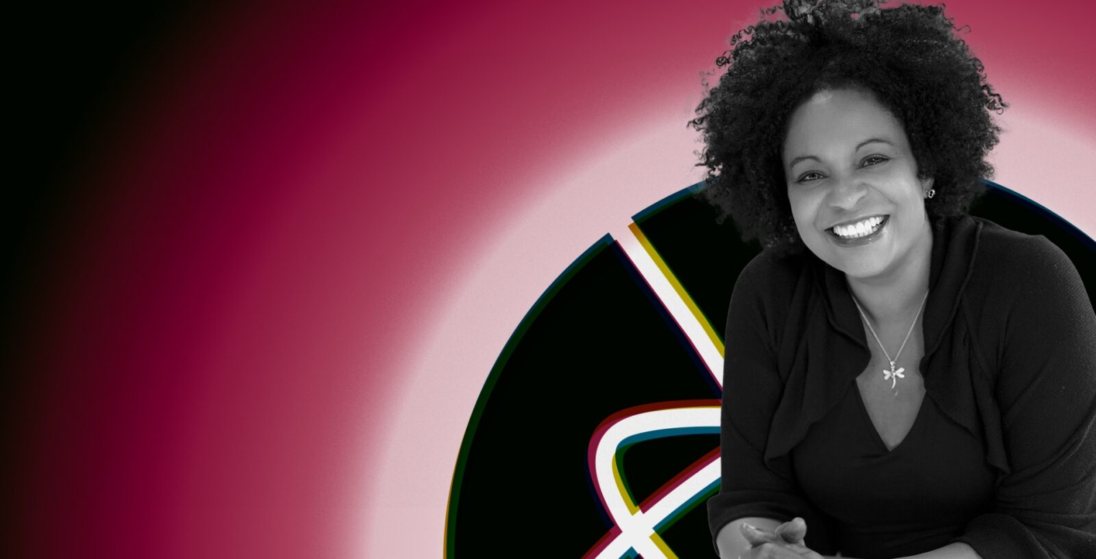 A woman with curly hair smiles in front of a colorful, abstract circular background with intersecting lines, embodying the vibrant spirit of Adler University president Lisa Coleman.