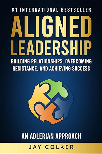 Book cover of "Aligned Leadership" by Jay Colker, an alumni author, featuring puzzle pieces forming a circle and text about building relationships, overcoming resistance, and achieving success through inspiring stories.